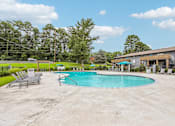 Thumbnail 29 of 37 - A swimming pool surrounded by concrete and lounge chairs.