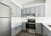 Thumbnail 17 of 18 - A modern kitchen with a stainless steel refrigerator and oven.