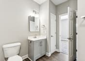 Thumbnail 15 of 18 - A white toilet sits next to a sink in a bathroom.
