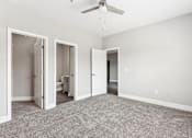 Thumbnail 10 of 18 - A room with a ceiling fan and carpeted floor.