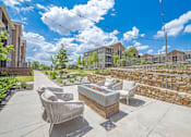 Thumbnail 36 of 44 - A patio with a fire pit and chairs.