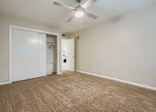 Thumbnail 3 of 27 - A room with a carpeted floor and a ceiling fan.