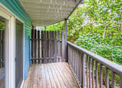 Thumbnail 8 of 27 - A wooden deck with a railing and a view of a green forest.