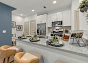 Thumbnail 3 of 44 - A kitchen with a countertop and two chairs.