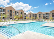 Thumbnail 32 of 44 - A large swimming pool in front of apartment buildings.