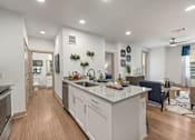 Thumbnail 2 of 44 - A modern kitchen with a large island and a dining area.
