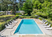 Thumbnail 5 of 18 - a swimming pool with white chairs and a fence around it