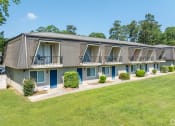 Thumbnail 10 of 18 - a building with blue doors and windows and a green lawn