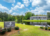 Thumbnail 1 of 18 - a large building with a lake and a sign in front of it