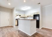 Thumbnail 13 of 37 - a kitchen with an island and a black refrigerator at Avenues of Kennesaw East & West, Kennesaw