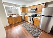 Thumbnail 1 of 18 - A kitchen with wooden cabinets and stainless steel appliances.