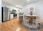 Thumbnail 2 of 31 - a kitchen and dining room with stainless steel appliances and a round table