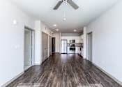 Thumbnail 14 of 27 - a living room with white walls and a ceiling fan