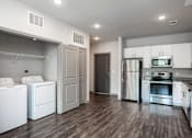Thumbnail 13 of 27 - a laundry room with white cabinets and stainless steel appliances