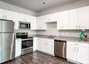 Thumbnail 12 of 27 - a kitchen with white cabinets and stainless steel appliances