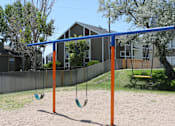Thumbnail 24 of 30 - A swing set with two swings and a blue bar.