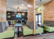 Thumbnail 11 of 29 - a common area with tables and chairs and a kitchenette in the background at Century Belmont Station, Louisville