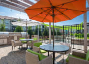 Thumbnail 6 of 29 - a patio with tables chairs and umbrellas at Century Belmont Station, Louisville, KY, 40243