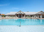 Thumbnail 17 of 29 - a large pool with lounge chairs and umbrellas in front of a building at Century Belmont Station, Louisville
