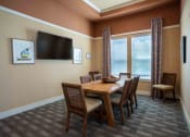 Thumbnail 14 of 30 - a dining room with a table and chairs and a television at Century Dunes Apartments, Deland, FL