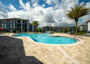 Thumbnail 16 of 30 - a large swimming pool in front of an apartment building at Century Dunes Apartments, Deland, Florida