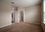 Thumbnail 26 of 30 - a living room with carpet and a door to a closet at Century Dunes Apartments, Deland, FL