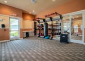 Thumbnail 4 of 30 - a gym with a punching bag and weights in the corner of a room at Century Dunes Apartments, Deland, 32724