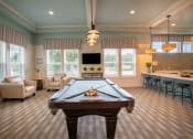 Thumbnail 12 of 30 - a game room with a pool table and a bar at Century Dunes Apartments, Florida