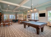 Thumbnail 11 of 30 - a game room with a pool table and tables at Century Dunes Apartments, Deland, Florida