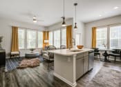 Thumbnail 22 of 32 - an open floor plan with a kitchen island and a living room with a couch and chairs at Century University City, North Carolina