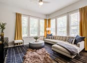 Thumbnail 18 of 32 - a living room with yellow curtains and a white couch at Century University City, Charlotte, NC