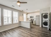 Thumbnail 19 of 32 - a kitchen and living room with a washer and dryer at Century University City, Charlotte, 28213