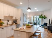 Thumbnail 18 of 28 - a kitchen with white cabinets and a large island with a bowl of fruit on it  at Century West Pryor, Lee's Summit, MO