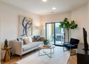 Thumbnail 15 of 28 - a living room with a couch coffee table and chair and a sliding glass door to a balcony  at Century West Pryor, Missouri, 64081