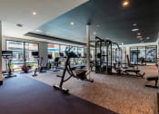 Thumbnail 25 of 28 - a gym with exercise equipment and large windows  at Century West Pryor, Lee's Summit, MO