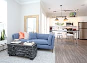Thumbnail 29 of 62 - A living room with a blue couch and a coffee table.