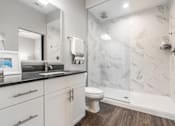 Thumbnail 34 of 62 - A bathroom with a marble wall and a toilet.