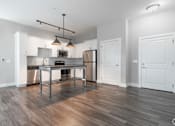Thumbnail 39 of 62 - A modern kitchen with a wooden floor and white walls.