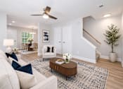 Thumbnail 5 of 21 - A living room with a white couch, a coffee table, and a ceiling fan.