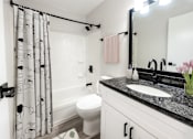Thumbnail 5 of 18 - A bathroom with a black and white shower curtain.