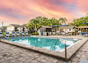 Thumbnail 17 of 17 - A swimming pool surrounded by a stone patio and lounge chairs.
