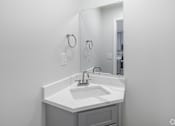 Thumbnail 19 of 25 - A white sink in a bathroom with a mirror above it.