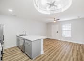 Thumbnail 3 of 25 - A kitchen with a white countertop and wooden flooring.