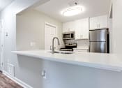 Thumbnail 19 of 81 - a kitchen with a counter top and a refrigerator at Magnolia Place at Stockbridge Apartments, Stockbridge, Georgia