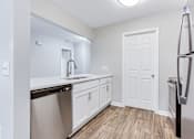 Thumbnail 22 of 81 - a renovated kitchen with white cabinets and a stainless steel refrigerator at Magnolia Place at Stockbridge Apartments, Georgia, 30281