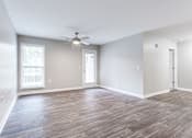 Thumbnail 24 of 81 - an empty living room with a ceiling fan and window at Magnolia Place at Stockbridge Apartments, Georgia, 30281