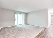 Thumbnail 33 of 81 - an empty living room with a sliding glass door at Magnolia Place at Stockbridge Apartments, Stockbridge, GA