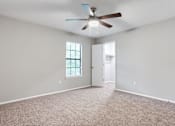 Thumbnail 41 of 81 - an empty living room with a ceiling fan at Magnolia Place at Stockbridge Apartments, Stockbridge, GA, 30281