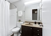 Thumbnail 43 of 81 - a bathroom with a sink toilet and a mirror at Magnolia Place at Stockbridge Apartments, Georgia