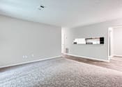 Thumbnail 34 of 81 - an empty living room with wood flooring and white walls at Magnolia Place at Stockbridge Apartments, Georgia, 30281